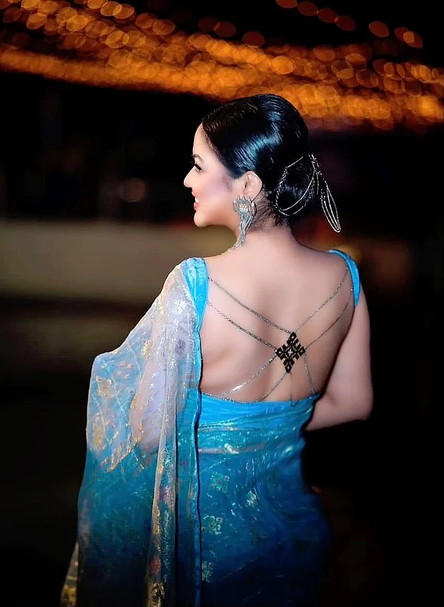 তাঁর ব্যাকলেস ব্লাউজে বডি জুয়েলারির আমেজে করা জামদানি কাটাই কাজ পুরো সাজে এনে দিয়েছে আলাদা মাত্রা। ঐতিহ্যবাহী জামদানির সঙ্গে আধুনিক নকশার এই ব্লাউজের মেলবন্ধন ভাবনার লুককে করেছে আরও আকর্ষণীয়