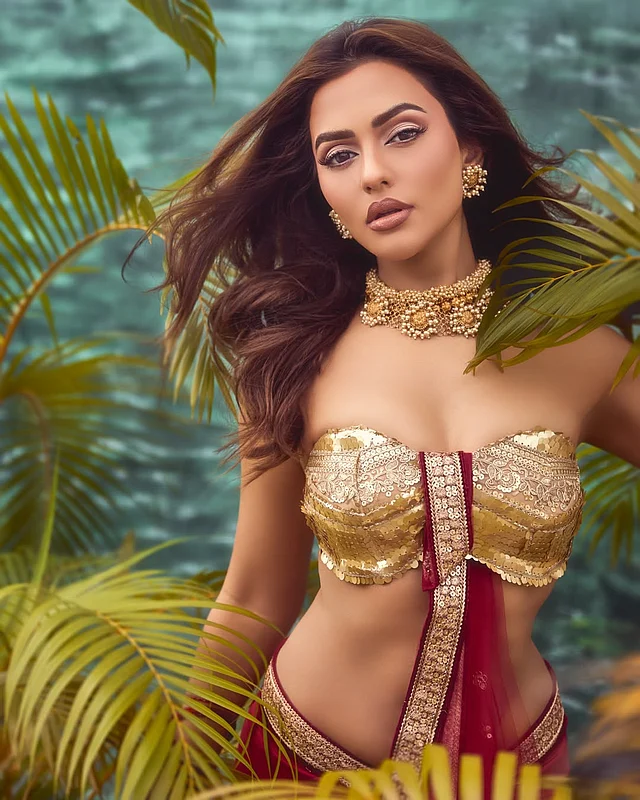 সোনালি পাড়ের লাল ফেব্রিকের দারুণ ড্রেপে পুরো আউটফিটে ফুঁটে উঠেছে আবেদন।
