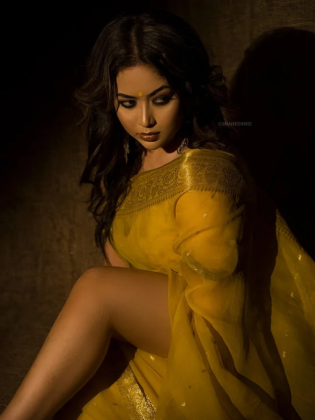 গায়ে জড়িয়েছেন সোনালি পাড় আর বুটির কাঁঠালিচাঁপার মতো হলুদ এক তাঁতের শাড়ি