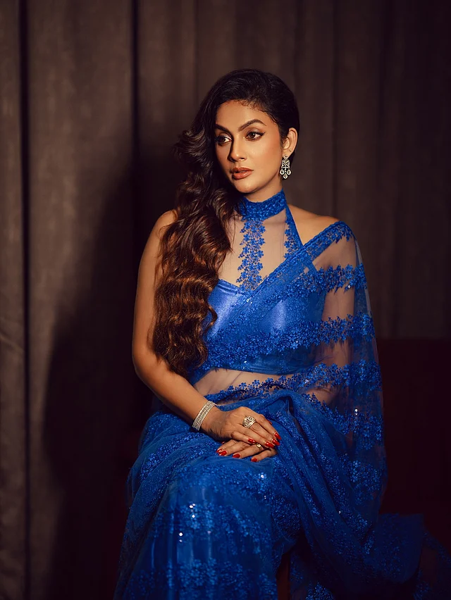 রয়্যাল ব্লু শিয়ার শাড়ির সঙ্গে পরেছেন মানানসই হাই-নেক হল্টার ব্লাউজ। চুলগুলো একপাশে কার্ল করে ছেড়ে রাখা আর সঙ্গে হীরার গয়নায় সেজেছেন।