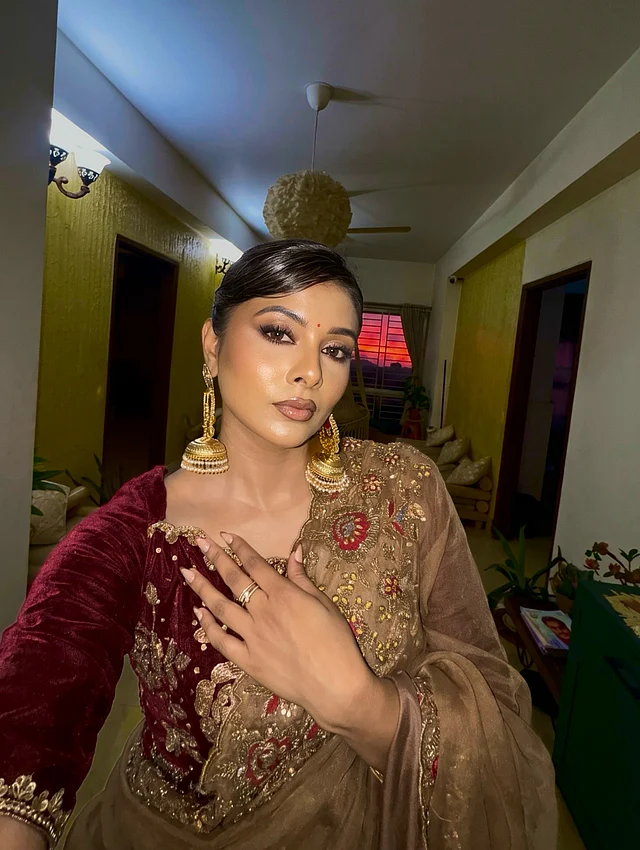 কানে শোভা পাচ্ছে ভারী সোনালি ঝুমকা। আর সেজেছেন আকর্ষনীয় ন্যুড মেকআপে