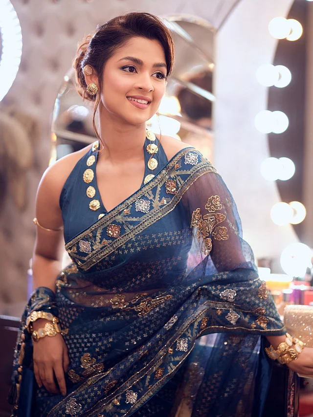 সাদিয়া আয়মান নেভি ব্লু জামদানি শাড়িটি স্টাইল করেছেন একই রঙের হল্টারনেক ব্লাউজের সঙ্গে। চিরচেনা শাড়ির সঙ্গে আধুনিক নেকলাইনের এই সমন্বয়ে ঐতিহ্য আর সমসাময়িক ফ্যাশন ধরা দিয়েছে একসঙ্গে।