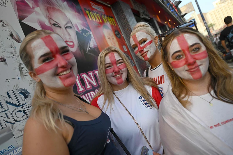 England's supporters with their face painted the colours of England's flag gather prior the 2026 World Cup semi-final match between England and Argentina on a giant screen in Benidorm, on Spain's eastern coast, on July 15, 2026. (Photo by JOSE JORDAN / AFP)