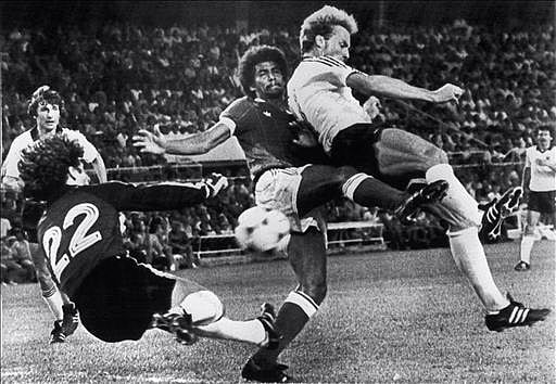 West German forward Karl-Heinz Rummenigge (C, right) scores the second goal for his team despite pressure from French defender Gerard Janvion and goalkeeper Jean-Luc Ettori during their World Cup semifinal soccer match on 08 July 1982 in Sevilla. West Germany beat France 5-4 on penalty kicks in the penalty shootout after the two teams were tied at 1 at the end of regulation time and at 3 at the end of the extra time period. Photo: AFP