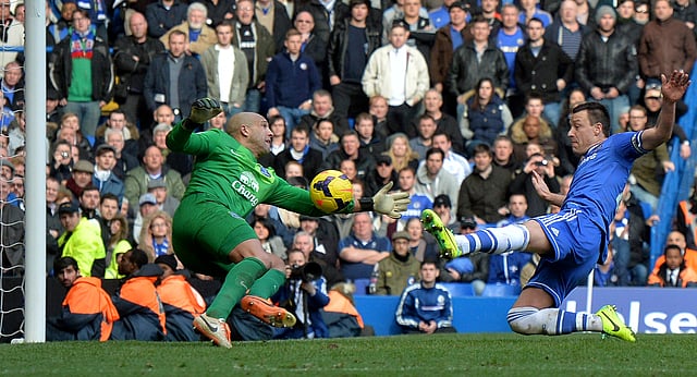 Chelsea's English defender John Terry (R) lunges toward the ball as Everton's US goalkeeper Tim Howard (L) fails to make the save leading to the winning goal from a free kick by Chelsea's English midfielder Frank Lampard during the English Premier League football match between Chelsea and Everton at Stamford Bridge in London on February 22, 2014. AFP