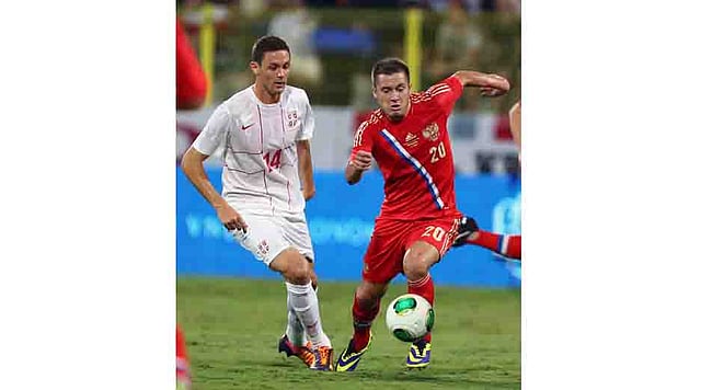 Victor Fayzulin of Russia vies with Nemanja Matic of Serbia (L) during their International friendly football match in Dubai's al-Wasl stadium on November 15, 2013. AFP