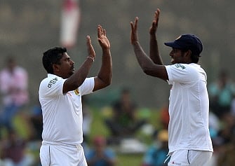 Sri Lankan cricket team captain Angelo Mathews (R) and teammate Rangana Herath celebrate after dismissing Pakistan batsman Khurram Manzoor during the fourth day of the opening Test match between Sri Lanka and Pakistan at the Galle International Cricket Stadium in Galle on August 9, 2014. AFP