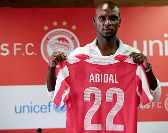 Veteran French defender Eric Abidal holds his new jersey numbered 22 after a press conference for his official presentation by his new football club Greek champions Olympiakos, on August 11, 2014 at the Karaiskaki stadium in Piraeus near Athens. AFP
