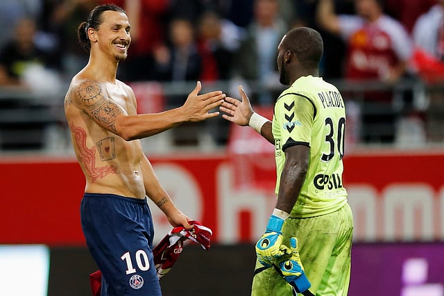 Zlatan Ibrahimovic (L) of Paris St Germain shakes with Reims goalkeeper Johny Placide after their French Ligue 1 soccer match at the Gustave Delaune Stadium in Reims August 8, 2014. Picture taken August 8, 2014. Reuters
