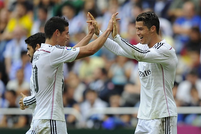 Real Madrid's Colombian midfielder James Rodriguez and Portuguese forward Cristiano Ronaldo celebrate after scoring during the Spanish league football match RC Deportivo de la Coruna vs Real Madrid CF at the Municipal de Riazor stadium in La Coruna. Photo: AFP