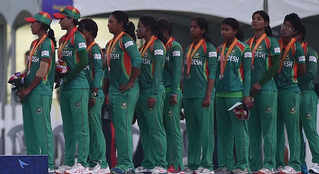 Silver medalists from Bangladesh stand for a flag rising ceremony after the medal ceremony following the women's cricket final at the Yeonhui Cricket Ground during the 17th Asian Games in Incheon on September 26, 2014. AFP