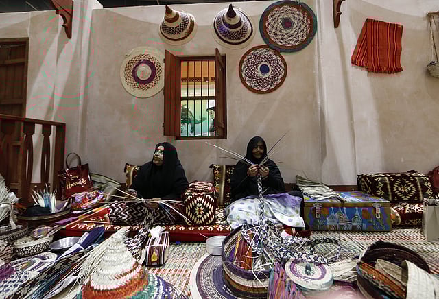 Emirati women make traditional baskets at the International Hunting and Equestrian exhibition in Abu Dhabi. Photo: AFP