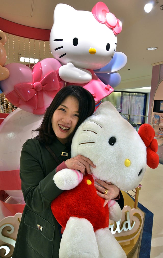 A 51-year-old mother Kazumi Kaminaga smiling with a large Hello Kitty doll at a Sanrio shop in Tokyo. Photo: AFP