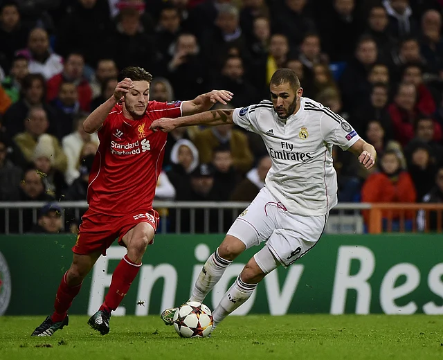 Real Madrid's French forward Karim Benzema vies with Liverpool's English midfielder Adam Lallana during the UEFA Champions League football match. Photo: AFP