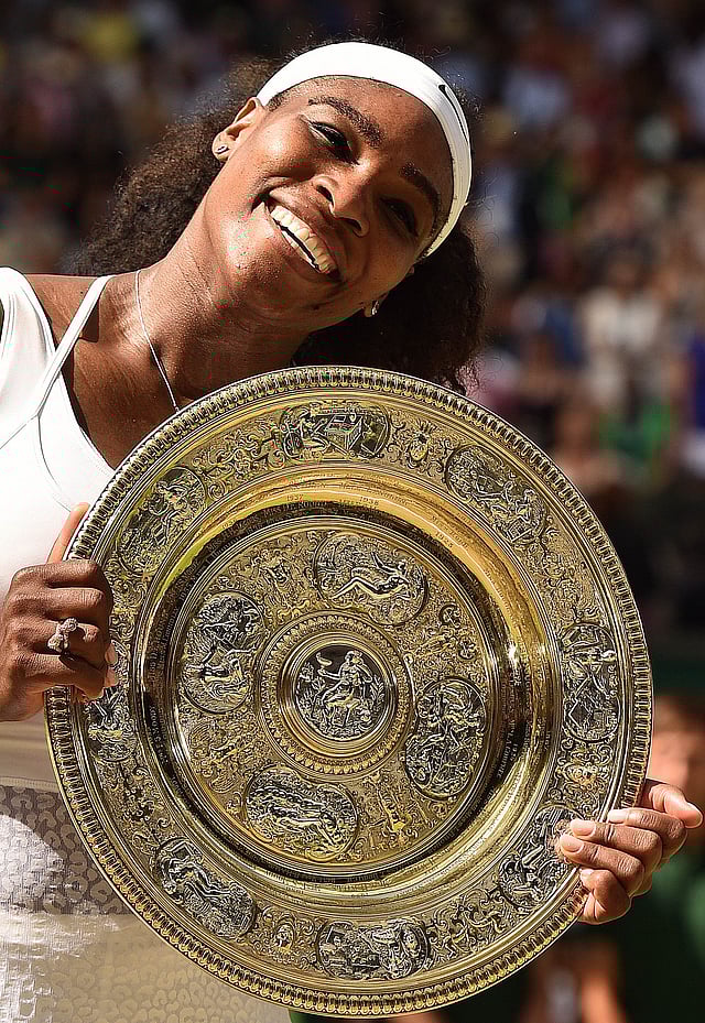 US player Serena Williams celebrates with the winner's trophy, the Venus Rosewater Dish, after her women's singles final victory over Spain's Garbine Muguruza on day twelve of the 2015 Wimbledon Championships at The All England Tennis Club in Wimbledon, southwest London, on July 11, 2015. AFP