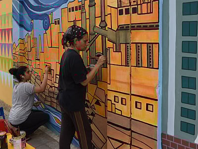 Art teacher Nooryya Shaikh Nabi (R) and her daughter Gaiti Ara make the final touches to a design on a wall in the southern port city of Karachi. Photo: AFP