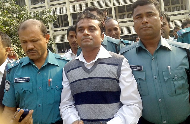Viqarunnisa Noon School teacher Parimal Joydhar, flanked by police personnel, appeared before the Women and Children Repression Prevention Tribunal-4 of Dhaka on Wednesday.
