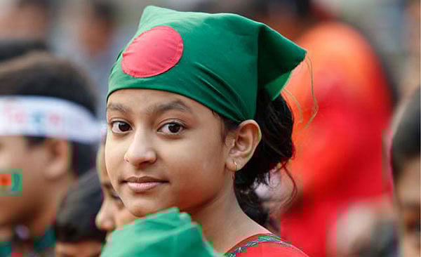 A girl has her head covered with the national flag of Bangladesh at the central Shaheed Minar in the capital. The photo was taken on 15 December. Photo: Hasan Raza