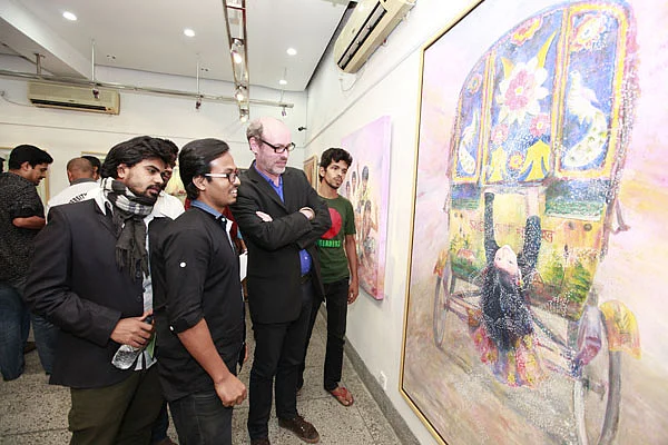 Visitors look at paintings at the solo art exhibition ‘Three Shadows of Art’ at Alliance Française de Dhaka on Friday. Photo: Prothom Alo