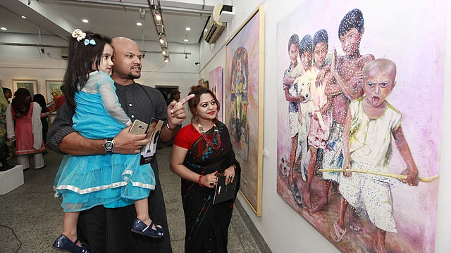 Visitors look at paintings at the solo art exhibition ‘Three Shadows of Art’ at Alliance Française de Dhaka on Friday. Photo: Prothom Alo