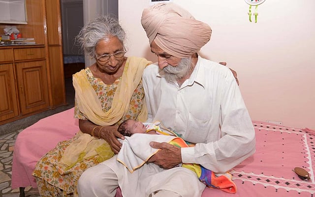 Indian parents Mohinder Singh Gill ®, 79, and Daljinder Kaur, 70, hold their newborn baby boy Arman at their home in Amritsar. Photo: AFP