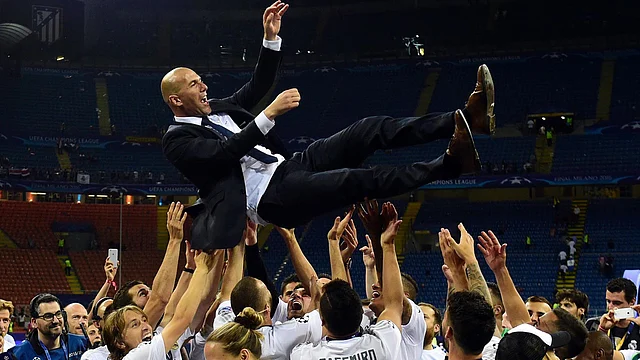 Real Madrid`s French coach Zinedine Zidane is lifted by his players after Real Madrid won the UEFA Champions League final football match between Real Madrid and Atletico Madrid at San Siro Stadium in Milan, on 28 May. Photo: AFP
