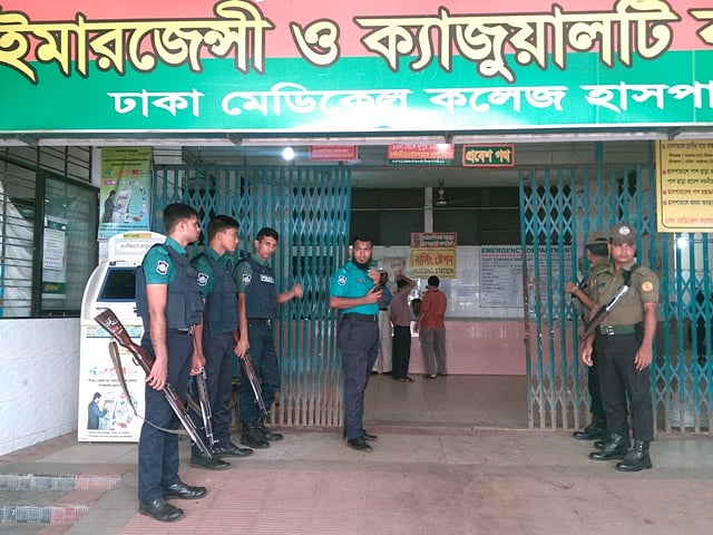 Policemen and security personnel guard in front of the DMCH emergency unit.