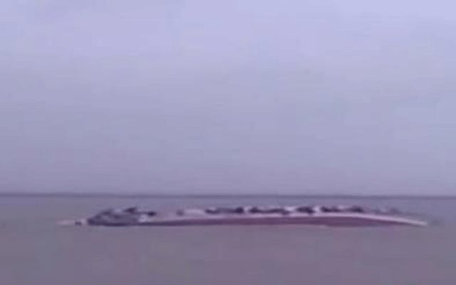 Capsized Pinak-6 is seen in the Padma River near Mawa Ghat in Lauhajang upazila of Munshiganj on Monday. TV grab