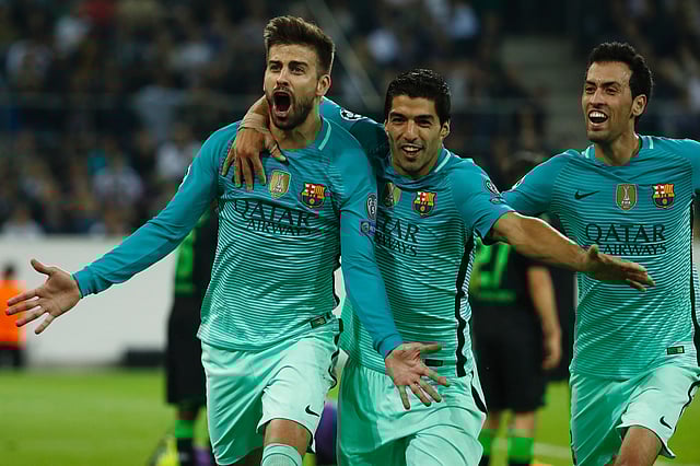 Barcelona`s defender Gerard Pique (L) celebrates scoring the 1-2 goal with his teammates Uruguayan forward Luis Suarez and midfielder Sergio Busquets during the UEFA Champions League first-leg group C football match between Borussia Moenchengladbach and FC Barcelona at the Borussia Park in Moenchengladbach, western Germany. Photo: AFP