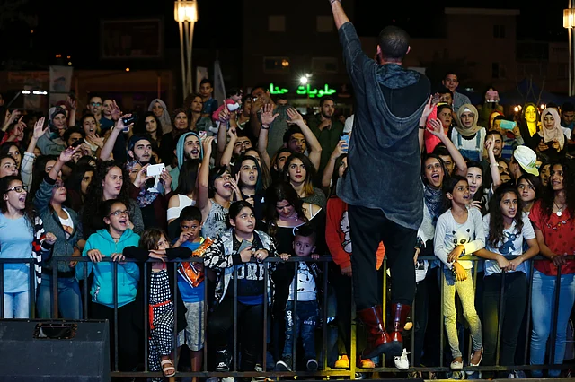 Audience members cheer as Arab-Israeli rapper Tamer Nafar performs on-stage during a festival in the northern Arab-Israeli town of Sakhnin. Photo: AFP
