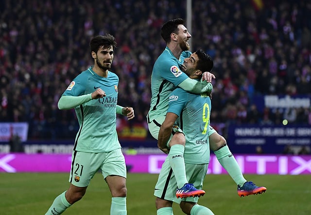 Barcelona’s Argentinian forward Lionel Messi © celebrates a goal with Barcelona’s Uruguayan forward Luis Suarez ® beside Barcelona’s Portuguese midfielder Andre Gomes during the Spanish Copa del Rey (King’s Cup) semi final first leg football match against Club Atletico de Madrid. Photo: AFP