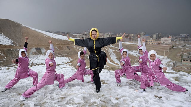Afghan members of a Wushu martial arts group led by trainer Sima Azimi ©, 20, pose for a photograph at the Shahrak Haji Nabi hilltop overlooking Kabul. Photo: AFP