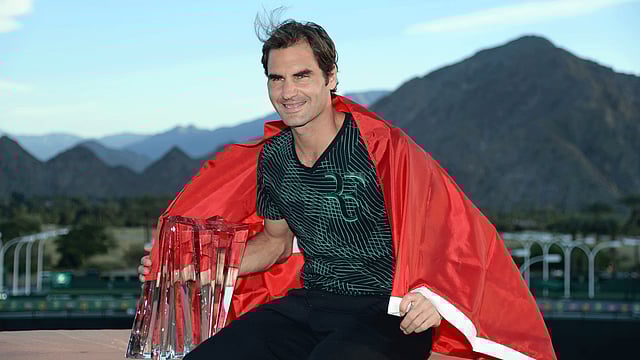 Roger Federer of Switzerland along with his BNP Paribas Open trophy poses for photographers after defeating Stan Wawrinka of Switzerland during the men`s final of the BNP Paribas Open at the Indian Wells Tennis Garden on 19 March 2017 in Indian Wells, California. AFP
