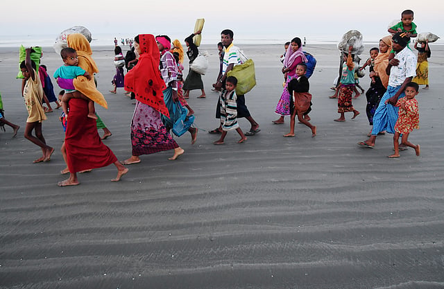Rohingya Muslim refugees who entered Bangladesh by boat walk towards refugee camps after landing at the Saplapur beach in the Teknaf district of Bangladesh on November 9, 2017. AFP