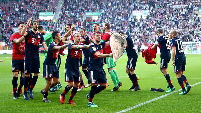 Bayern Munich players celebrate winning the league with a replica trophy in front of the fans at the end of the match on 7 April, 2018.