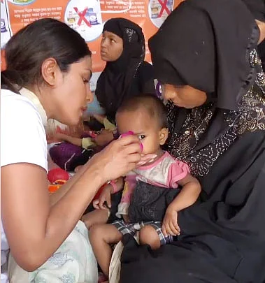 Priyanka Chopra offering food to a Rohingya child. Photo : facebook