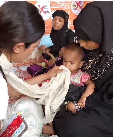 Priyanka Chopra cleans face of a Rohingya child with her scarf. Photo : facebook
