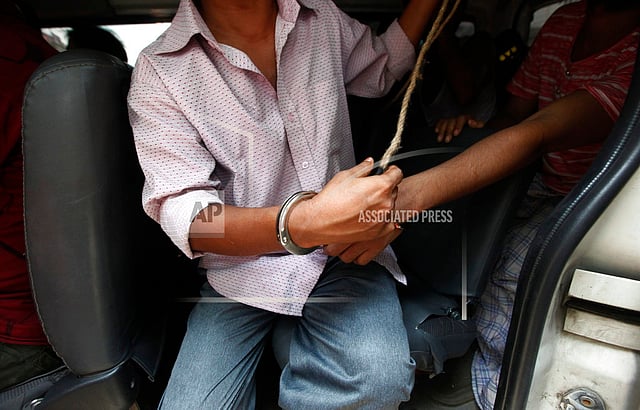 A suspected drug dealer is arrested by Bangladesh`s Rapid Action Battalion (RAB) soldiers during a raid on drug dealers at Mohammadpur Geneva Camp in Dhaka, Bangladesh on 26 May. Photo: AP