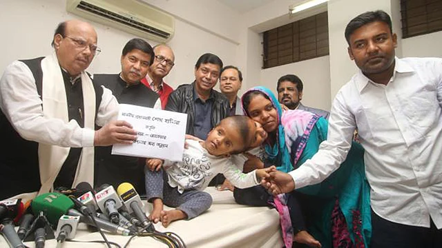 Cojoined Twin baby CAPTION: Health minister Mohammed Nasim handed over the PM’s grants to the twins’ parents at a media briefing at the DMCH on Friday morning. Photo: Prothom Alo