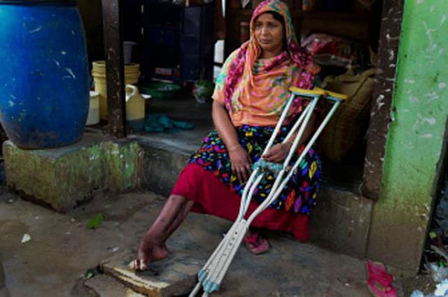 In this photograph taken on April 17, 2018 Nilufer Begum, an injured garment worker who survived the Rana Plaza disaster, sits with her crutches by her small tea stall in Savar, northwest of the Bangladeshi capital Dhaka. File Photo