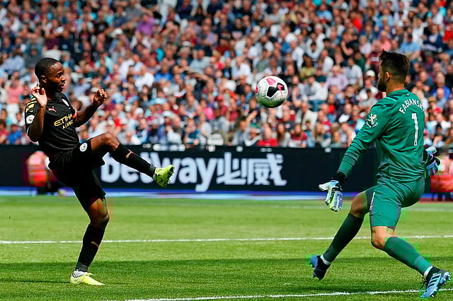 Manchester City`s English midfielder Raheem Sterling (L) lifts the ball over West Ham United`s Polish goalkeeper Lukasz Fabianski (R) to score their third goal during the English Premier League football match between West Ham United and Manchester City at The London Stadium, in east London on 10 August, 2019.