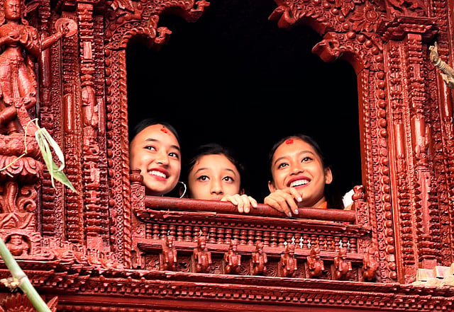 Matina Shakya (C), a former Kumari, watches as another child is revered as a living goddess or Kumari, during a chariot procession on the main day of the Indra Jatra festival at Basantapur Durbar Square in Kathmandu on 13 September 2019. Photo: AFP