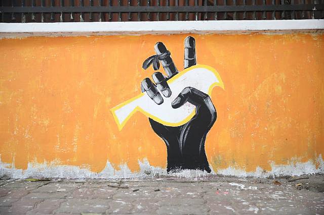 A dove, the symbol of peace, is caught in a hand that flashes a V (victory) sign.