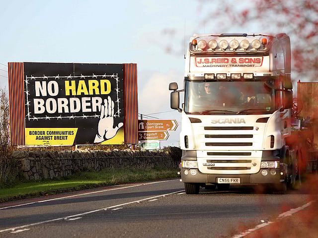 A lorry driver passes an anti-Brexit `No Hard Border` as he drives in Newry, Northern Ireland on 16 October 2019, on the road crossing the border between Newry and Dundalk in Ireland. Photo: AFP