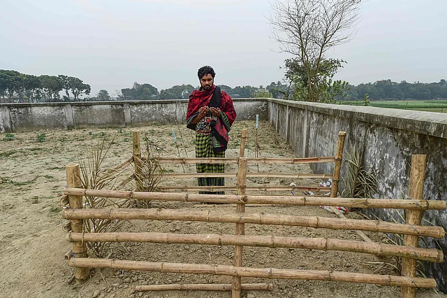 This photograph taken on 8 February shows Mukul Seikh praying in front of the grave of his mother, former sex worker Hamida Begum, in Daulatdia in Rajbari District, 110 kms (70 miles) west of Dhaka.Photo: AFP