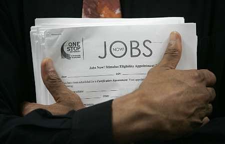 নতুন চাকরির খবরাখবরের বুলেটিন নিয়ে অপেক্ষমাণ এক মার্কিন যুবক। ছবি:রয়টার্স।