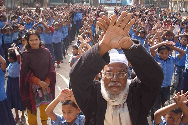 নাছু মামুদ সরকারি প্রাথমিক বিদ্যালয়ের প্রাত্যহিক সমাবেশে শিশুদের সঙ্গে আবদুল করিম | ছবি: মকবুল হোসেন