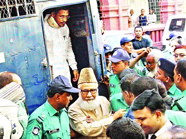 দশ ট্রাক অস্ত্র মামলার রায় ঘোষণার আগে গতকাল বেলা সোয়া ১১টায় আদালত প্রাঙ্গণে প্রিজনভ্যান থেকে নামছেন সাবেক শিল্পমন্ত্রী ও জামায়াতের আমির মতিউর রহমান নিজামী এবং সাবেক স্বরাষ্ট্র প্রতিমন্ত্রী লুৎফুজ্জামান বাবর । ছবি: সৌরভ দাশ