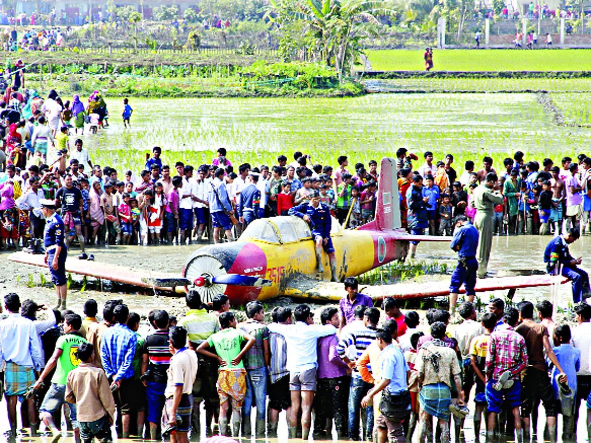 বাংলাদেশ বিমানবাহিনীর প্রশিক্ষণ বিমান পিটি-৬ যান্ত্রিক ত্রুটির কারণে গতকাল যশোর সদর উপজেলার মাহিদিয়া গ্রামে ধানখেতে পড়ে যায়। এ সময় আশপাশের লোকজন বিমানটি দেখতে ভিড় জমান । ছবি: এহসান-উদ-দৌলা