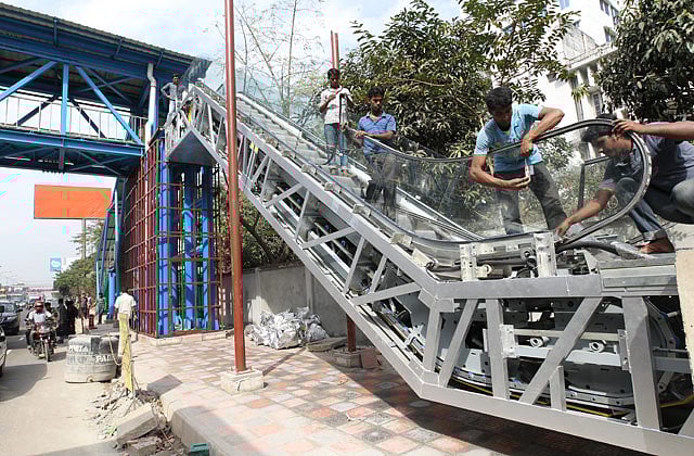 পদচারী সেতুতে ওঠার জন্য চলন্ত সিঁড়ি স্থাপনের কাজ চলছে রাজধানীর বনানী এলাকায়। গতকাল তোলা ছবি । প্রথম আলো